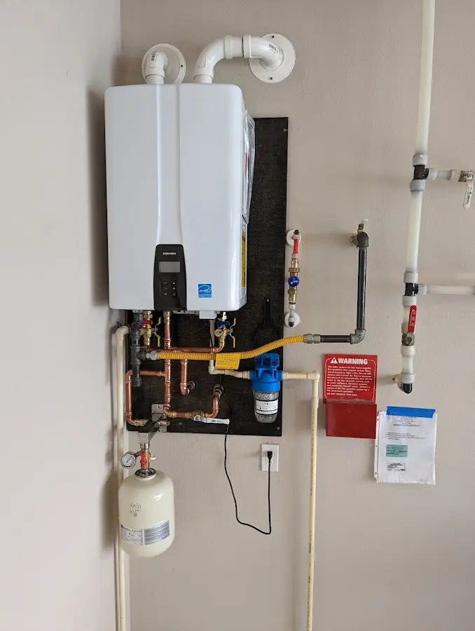 Professional plumber installing copper piping in a Groveton home